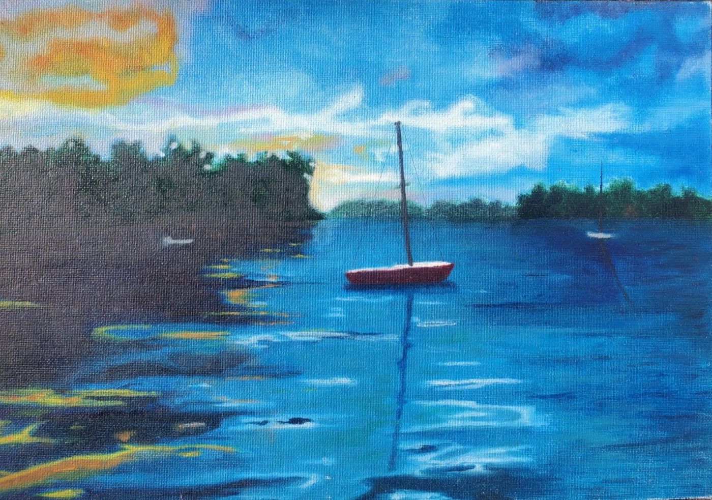 A small red sailboat at anchor on a calm harbor at dusk